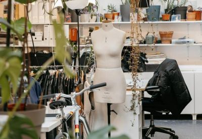 Creative studio space with a dressmaker's mannequin, indoor plants, and a bicycle.