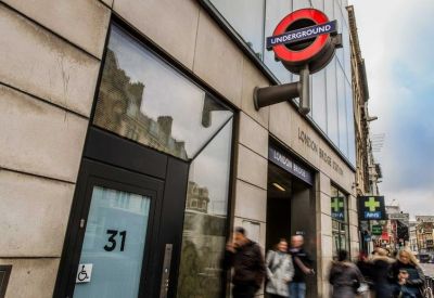 Modern stone entrance with a London Underground roundel sign and street numbering.
