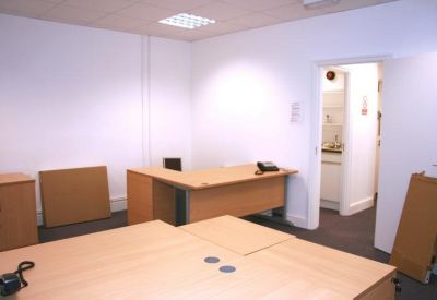 Office with several desks and overhead lighting.