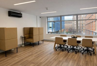 Spacious meeting area featuring a long white table and acoustic privacy booths.