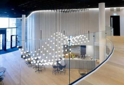 Grand multi-story lobby with a dramatic wave-like light installation.
