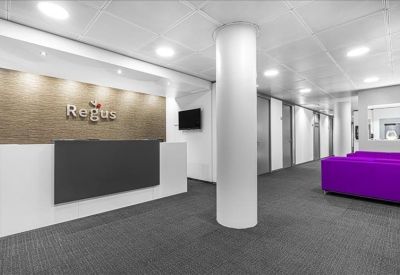 Modern reception area with a sleek desk, white pillar, and purple seating.