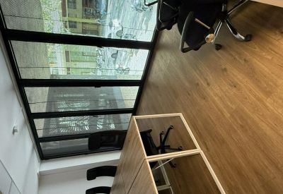 Interior workspace with a desk and city window view at 87, Passeig de Sant Gervasi.