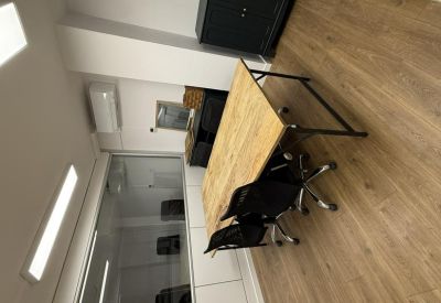 Private office featuring wooden desks behind a glass partition.