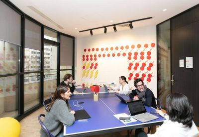Team workspace featuring a blue ping-pong style table and colorful wall art.