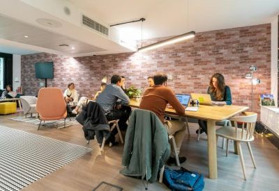 Casual meeting area with a brick-patterned feature wall and long wooden table.