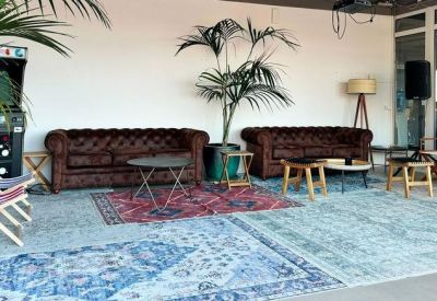 Inviting lounge area featuring classic leather Chesterfield sofas and vibrant patterned rugs.