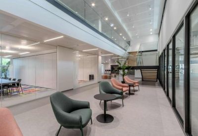 Two-story atrium lobby with modern lounge seating and a glass-walled mezzanine.