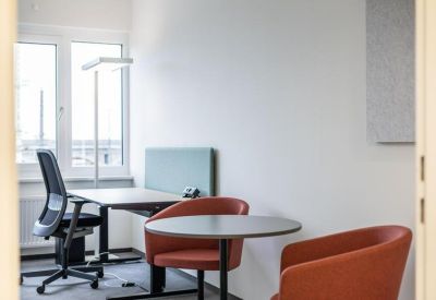 Private office space with two desks and comfortable orange armchairs.