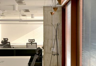 Office corridor featuring a concrete pillar and unique geometric pendant lighting.