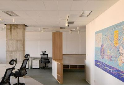 Spacious open-plan workspace with ergonomic chairs and wooden room dividers.