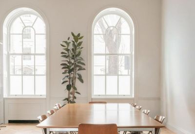 Spacious boardroom at 9, Stratford Place with high arched windows and a large wooden table.