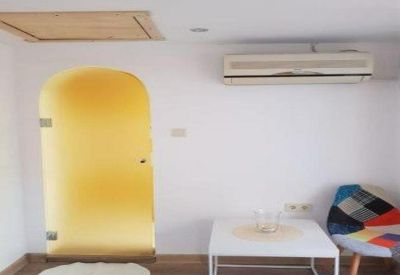 Bright office space with a yellow arched nook and modern air conditioning unit.