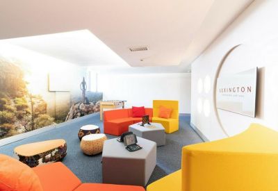 Spacious lounge area with vibrant orange and yellow modular seating and wall murals.