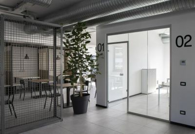 Coworking area with glass partitions and indoor plant.