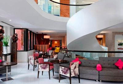 Spacious lobby at 96 Kensington High Street, London, featuring a sculptural white spiral staircase and lounge seating.