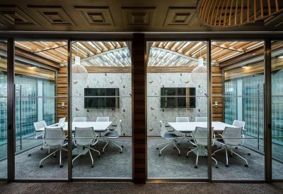 Modern glass-walled meeting rooms with wooden slat ceilings and white ergonomic chairs.