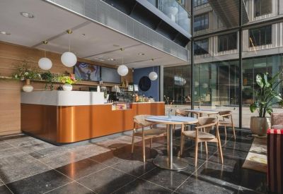 Sleek reception area with a copper-toned front desk and white globe pendant lights.