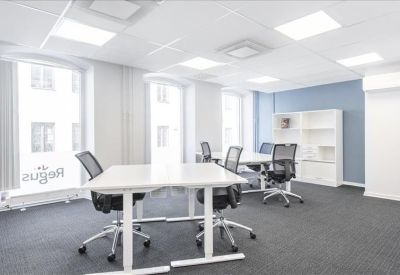 Open-plan workspace featuring white height-adjustable desks and ergonomic mesh chairs.