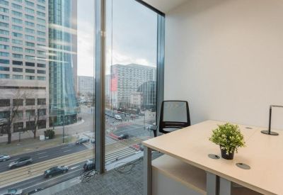 Single workstation by a large floor-to-ceiling window overlooking the city skyline.