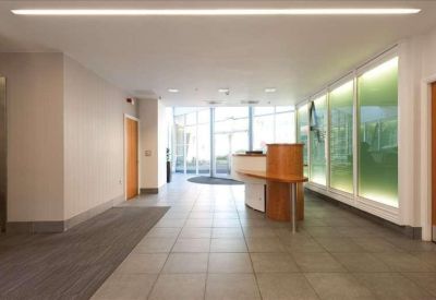 Minimalist reception area with grey tiled floors and frosted glass partitions.