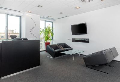 Contemporary reception area with a sleek black desk, modern seating, and wall art.