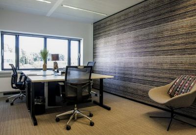 Minimalist private office with two desks, ergonomic chairs, and a horizontal wood-slat feature wall.