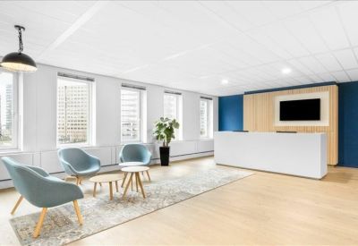 Bright reception area with white desk, blue feature wall, and comfortable lounge seating.