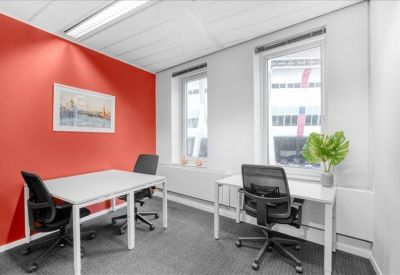 Private office suite with two white desks and a vibrant orange feature wall.
