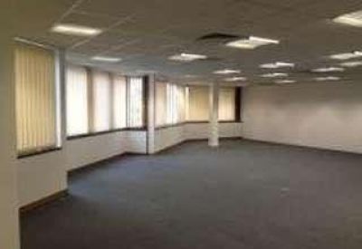 Large workspace with a central pillar and rows of ceiling light panels.