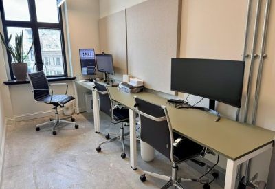 Private office suite with a three-person desk setup and ergonomic black chairs.
