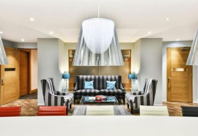 Sleek reception area with striped armchairs and a grey sofa.