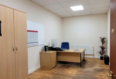 Private office suite with a large wooden desk and integrated storage unit.