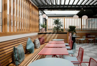 Covered outdoor seating area with wooden slats and comfortable cushions.