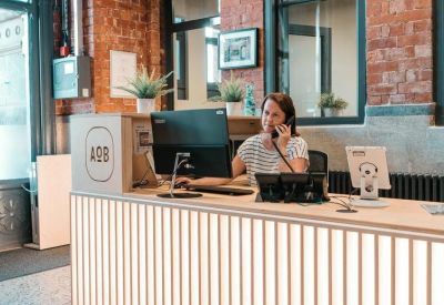Professional reception desk with a striped facade and a receptionist on a phone call.