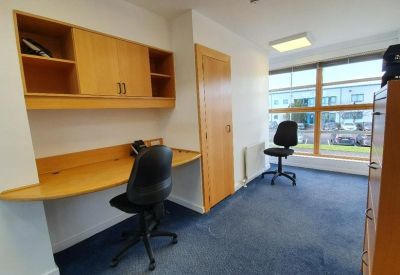 Internal office featuring a built-in wooden desk, storage cabinets, and natural light.