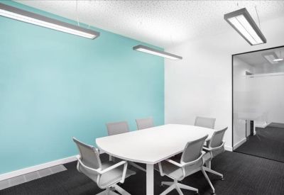 Modern meeting room featuring a white table and light blue accent wall.