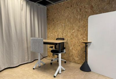 Private office workstation featuring a light wood desk against an OSB accent wall.