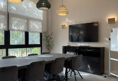 Professional meeting room with a stone-top table, wall-mounted TV, and woven pendant lamps.