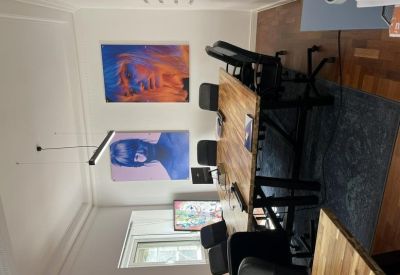 Meeting room featuring a large wooden table and contemporary blue portrait wall art.