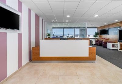 Bright reception area featuring a white and wood desk and striped feature wall.