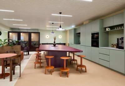 Spacious communal kitchen area with a large purple island and green cabinetry.