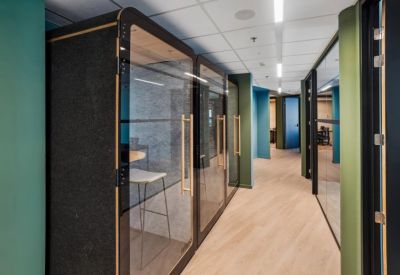 Hallway featuring soundproof private phone booths with wood and glass doors.