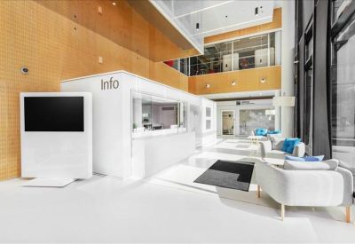 Modern lobby with white info desk and comfortable lounge seating.