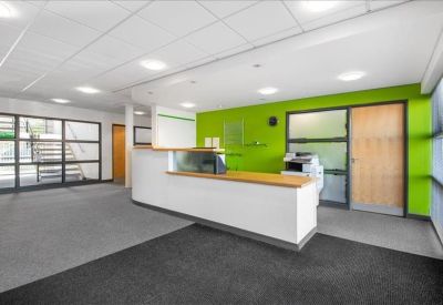 Bright reception area with a white front desk against a vibrant lime green feature wall.