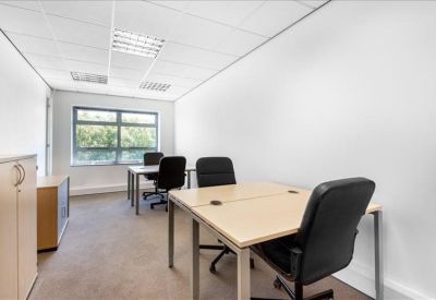 Bright private office suite with two wooden desks and black ergonomic chairs.