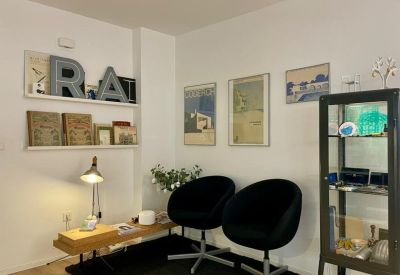 Comfortable waiting or reception area with two black velvet armchairs and decorative shelving.