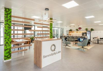Modern reception area with wood-slat partition and green moss-covered pillar.