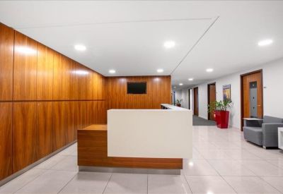 Bright reception area featuring a white and wood desk and a sleek tiled floor.