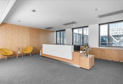 Bright reception area featuring a minimalist wood desk and two yellow accent chairs.